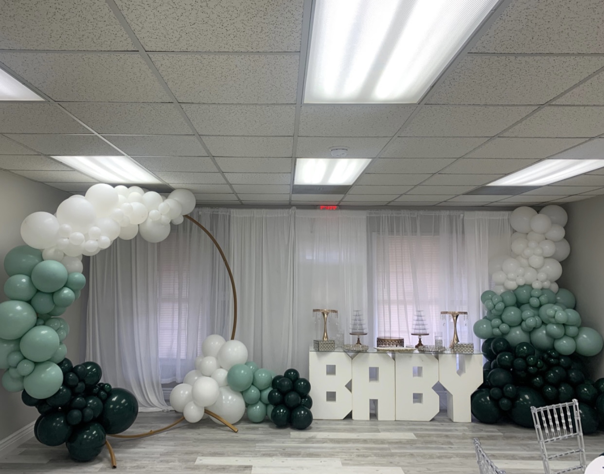 Green and white balloon backdrop with BABY letters