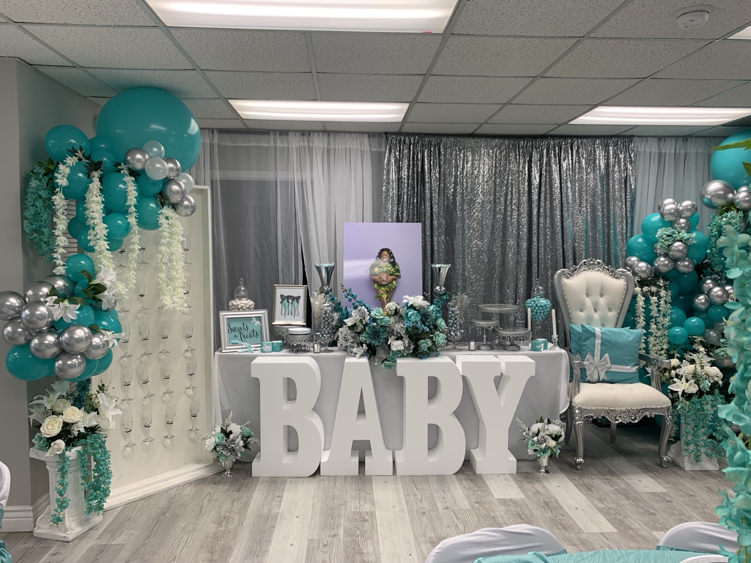 Teal baby shower backdrop with balloon garlands and BABY letters
