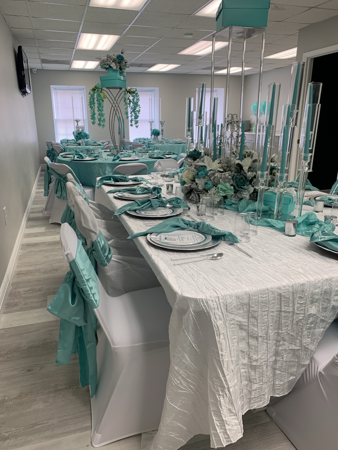 Teal and white baby shower tablescape with tall centerpieces