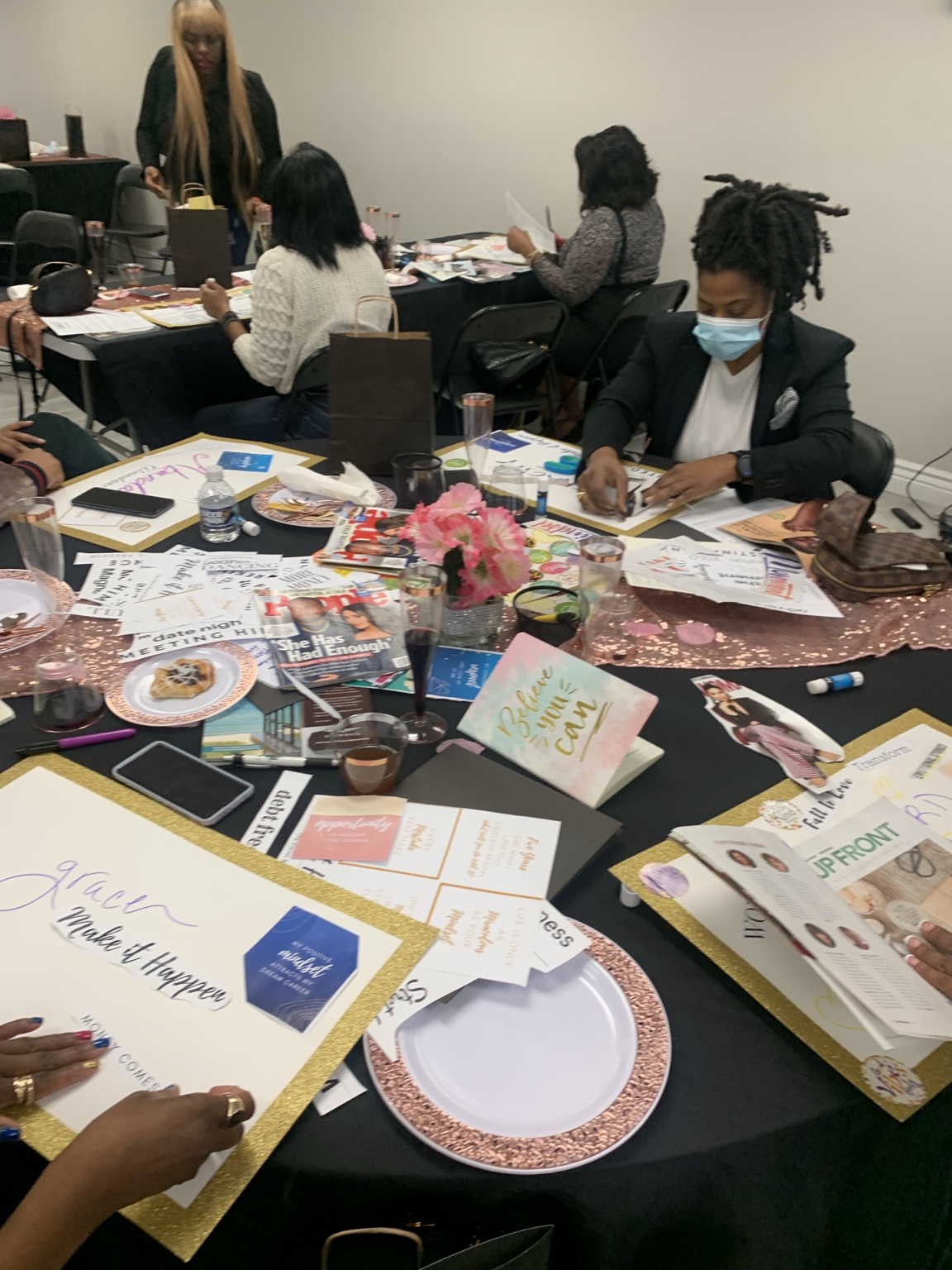 Guests creating vision boards at decorated workshop tables