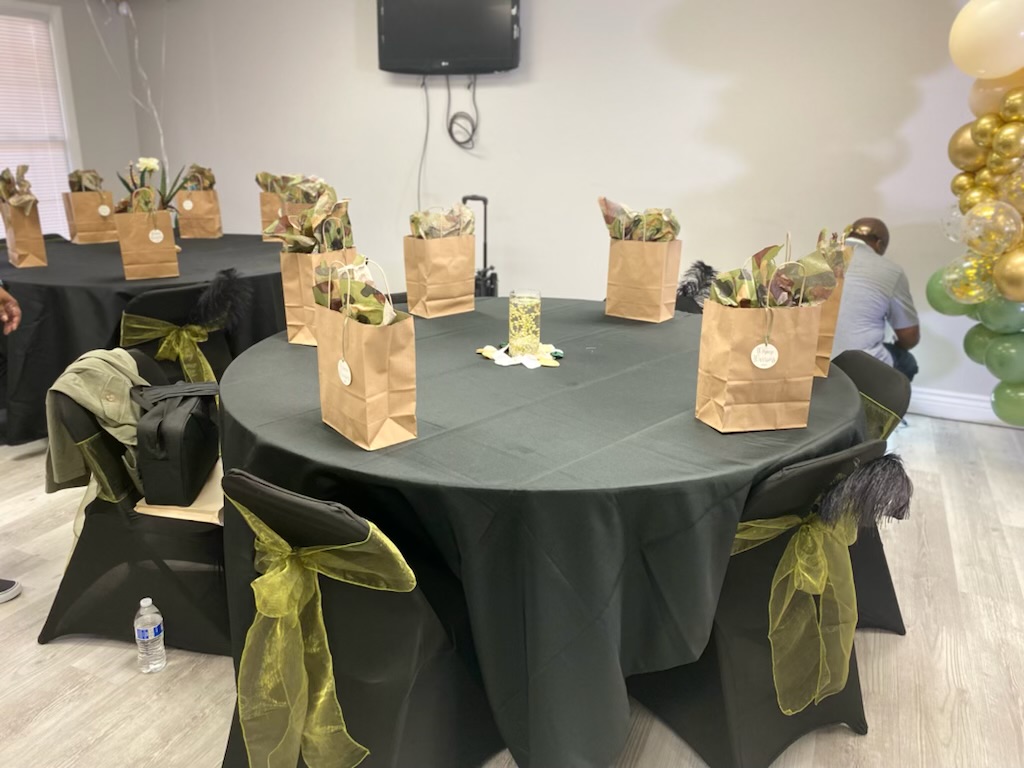 Round event tables with green chair sashes and gift bags